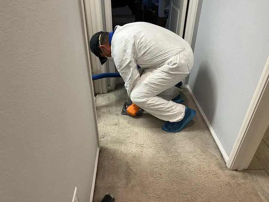 A technician checking a moisture reading in a San Gabriel Valley home