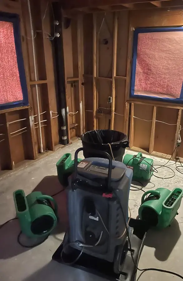 Opened wall and drying equipment after a burst pipe in a San Marino home