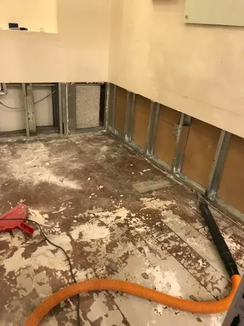 Wall opened and dried after a corroded copper pipe leak in an older San Marino home